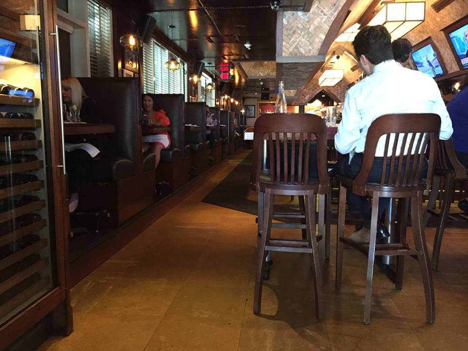 a bar with people sitting in high top tables