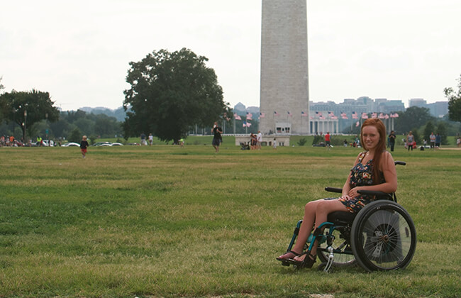 image of beautiful woman sitting on a wheelchair and smiling in a garden