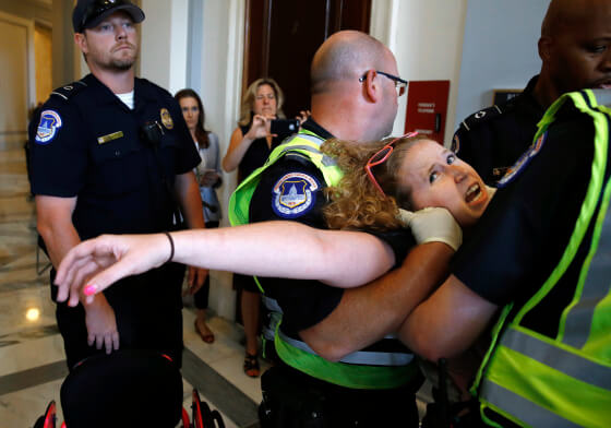 A women being carried off by two officers