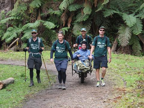 man in trailrider with group of hikers