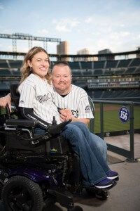 image of a man and a disabled woman sitting on his lap looking happy