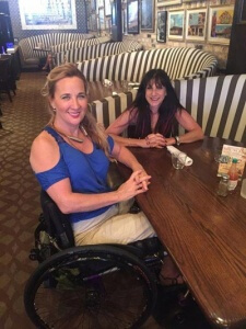A woman and a girl sitting in wheelchair accessible booths