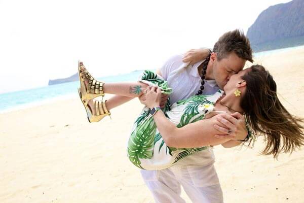 Kristina Rhoades and husband Jacob standing near a beach and kissing