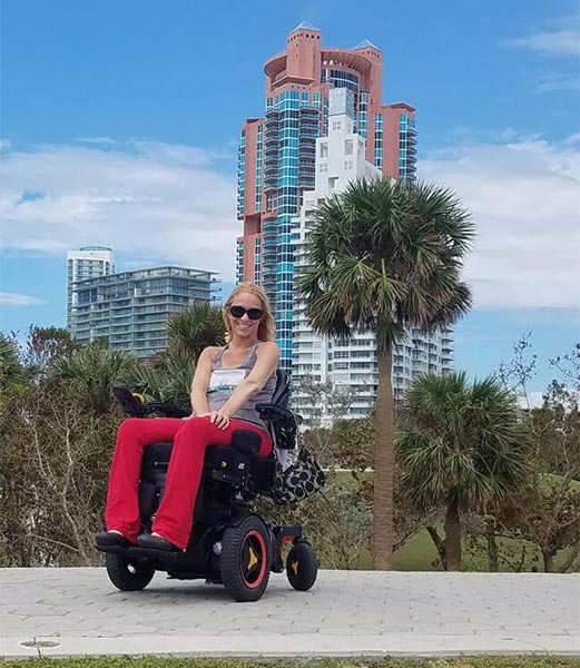 young disabled gorgeous blonde woman in a power wheelchair enjoying a beach vacation