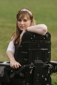 PL NPBKKTE original 1 200x300 - Young woman in a power wheelchair enjoying her home garden