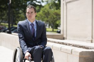 PL 0TCJTY5 original 300x200 - Young businessman in a suit and tie using a wheelchair