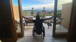 woman in wheelchair looking at window